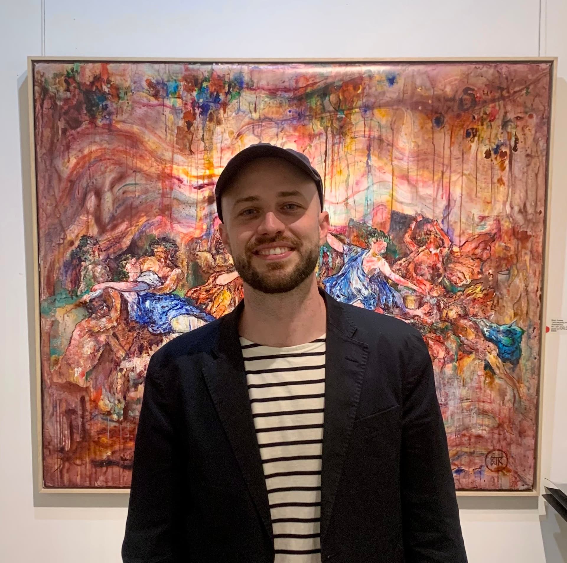 Artist standing before his painting on a wall.